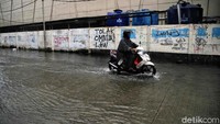 Hujan deras yang mengguyur pagi tadi membuat jalan ini tergenang.