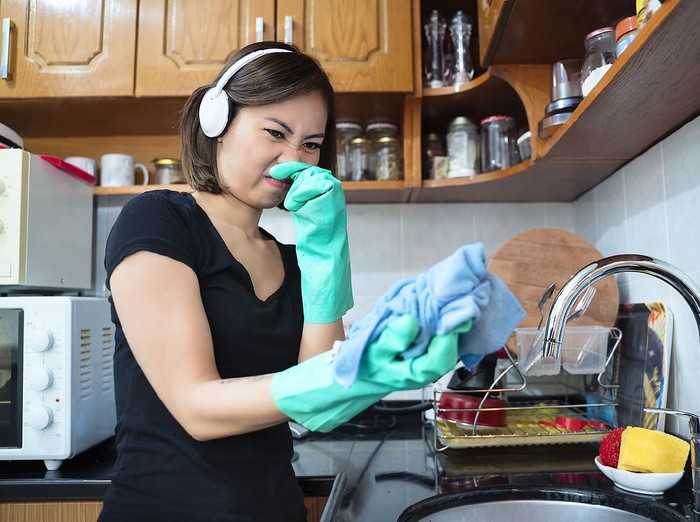 Woman cleaning kitchen with stinky clothe