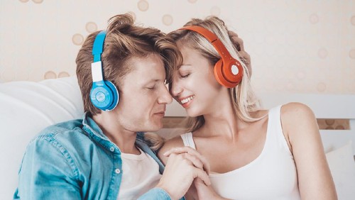Happy couple listening song in the morning at bedroom