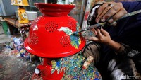Perajin mengecat ulang lampu ceting atau tempat nasi bekas untuk dijadikan karya seni di Pasar Kliwon, Solo, Jawa Tengah, Selasa (16/2/2021). 