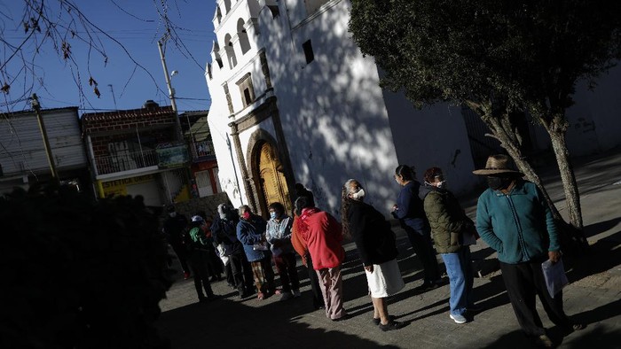 A wheelchair-bound elderly person who got a shot of the AstraZeneca vaccine against COVID-19 is pushed to an observation area, at a vaccination center set up in the Magdalena Contreras area of Mexico City, Monday, Feb. 15, 2021, as Mexico starts vaccinating people over age 60 against the new coronavirus. (AP Photo/Marco Ugarte)