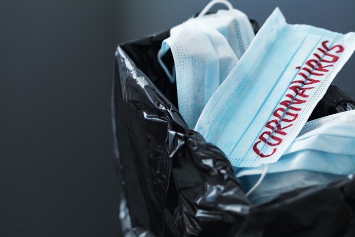 Used medical masks against coronavirus in trash can. Corona virus or covid-19 finish concept.