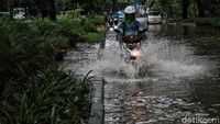 Pemotor memilih sisi kanan jalan yang genangannya lebih rendah.