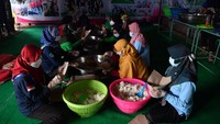 Sejumlah relawan membungkus makanan untuk dibagikan pengungsi dan petugas di dapur umum tanah longsor di Ngetos, Nganjuk, Jawa Timur.
