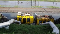 Pekerja berada di sekitar mesin pompa khusus penyedot banjir yang terletak di pinggir tanggul penahan Lapindo, Porong Sidoarjo, Jawa Timur, Selasa (16/2/2021).