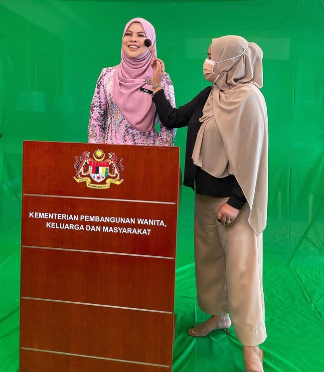 Dalam unggahan Instagram @saidatulnisaaminuddin terlihat bahwa sang MUA tengah mendandani Rina sebelum tampil dalam acara Kementerian Pembangunan Wanita, Keluarga dan Masyarakat. Rina tampak cantik dengan balutan hijab berwarna merah muda dan pakaian senada. Foto: Instagram/@saidatulnisaaminuddin