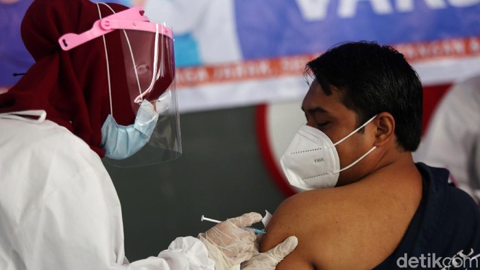 Petugas menyuntikan vaksin COVID-19 kepada pedagang di Pasar Tanah Abang Blok A, Jakarta, Rabu (17/2/2021). Vaksinasi COVID-19 tahap kedua yang diberikan untuk pekerja publik dan lansia itu dimulai dari pedagang Pasar Tanah Abang.