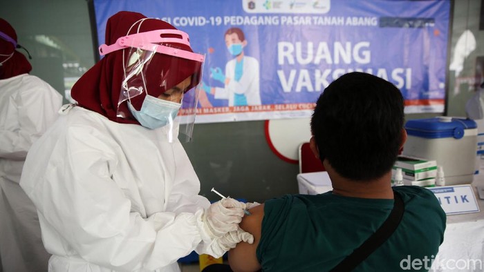 Petugas menyuntikan vaksin COVID-19 kepada pedagang di Pasar Tanah Abang Blok A, Jakarta, Rabu (17/2/2021). Vaksinasi COVID-19 tahap kedua yang diberikan untuk pekerja publik dan lansia itu dimulai dari pedagang Pasar Tanah Abang.