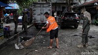 Salah satu pedagang yang melanggar prokes diberi sanksi bersih-bersih halaman.