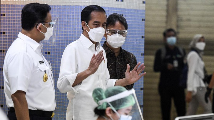 Presiden Joko Widodo (tengah) didampingi Menteri Kesehatan Budi Gunadi Sadikin (kanan) dan Gubernur DKI Jakarta Anies Baswedan meninjau vaksinasi COVID-19 massal bagi pedagang di Pasar Tanah Abang Blok A, Jakarta, Rabu (17/2/2021). Vaksinasi COVID-19 tahap kedua yang diberikan untuk pekerja publik dan lansia itu dimulai dari pedagang Pasar Tanah Abang. ANTARA FOTO/Hafidz Mubarak A/wsj.