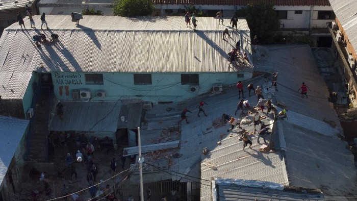 Kerusuhan di Penjara Paraguay, 6 Napi Tewas Inmates throw bricks at the police from the roof of Tacumbu prison during a riot and after they took control of the place in Asuncion, Paraguay, Tuesday, Feb. 16, 2021. (AP Photo/Jorge Saenz)