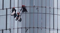 Para pekerja pembersih kaca gedung pencakar langit terlihat menggunakan standar operasional Keselamatan dan Kesehatan Kerja (K3) di kawasan Rasuna Said, Jakarta, Rabu (17/2/2021).