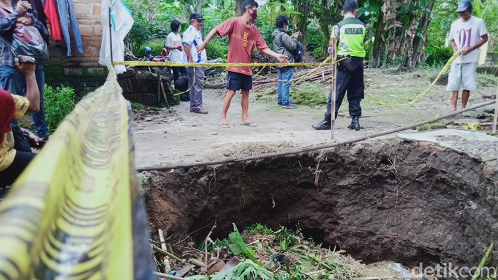 Petugas memasang garis polisi di sumur warga Klaten yang ambles, Rabu (17/2/2021).