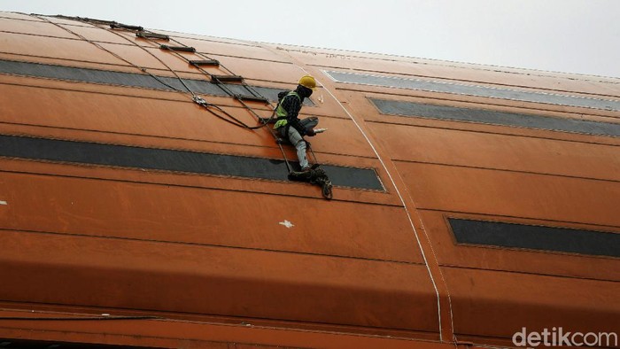 Banyak jenis pekerjaan yang dilakukan di ketinggian, seperti konstruksi. Meski cuaca mendung, mereka tetap menyelesaikan pekerjaannya di ketinggian.
