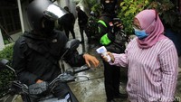 Mereka juga melakukan pengecekan suhu tubuh terhadap warga.