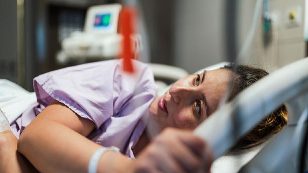 Young Pregnant woman getting ready for Natural Childbirth while lying in her hospital bed