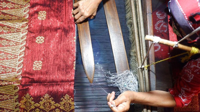 Seorang perajin memintal benang sebelum ditenun mnejadi kain Songket Silungkang.
