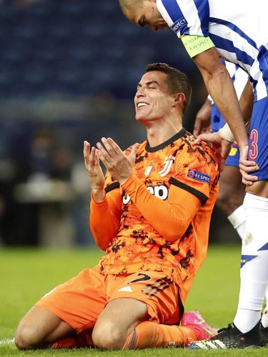 Porto's Pepe watches as Juventus' Cristiano Ronaldo gestures on the ground during the Champions League round of 16, first leg, soccer match between FC Porto and Juventus at the Dragao stadium in Porto, Portugal, Wednesday, Feb. 17, 2021. (AP Photo/Luis Vieira)