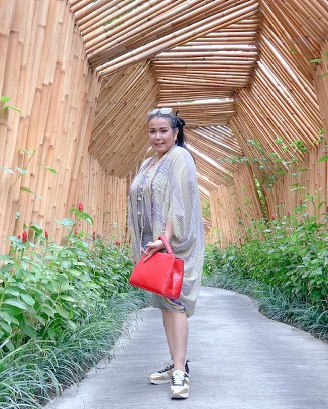Memadukan gaya chic dan sporty dengan sneakers dan tote bag merah. Ini penampilan Jennifer Jill saat bergaya casual. Foto: Instagram/@jennifer_ipel