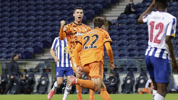 Juventus' Cristiano Ronaldo celebrates after teammate Federico Chiesa, center, scored their side's first goal during the Champions League round of 16, first leg, soccer match between FC Porto and Juventus at the Dragao stadium in Porto, Portugal, Wednesday, Feb. 17, 2021. (AP Photo/Luis Vieira)