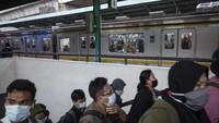 Calon penumpang menunggu kedatangan kereta di Stasiun Manggarai, Jakarta, Kamis (18/2/2021). Sejumlah perjalanan Kereta Rel Listrik (KRL) lintas Manggarai-Bogor mengalami gangguan operasional akibat banjir di kawasan Stasiun Tebet.