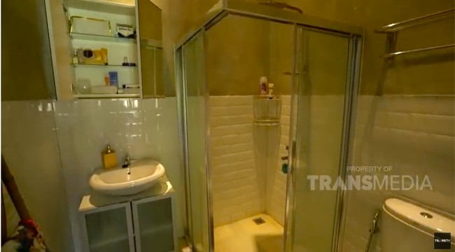 Inilah bagian kamar mandi yang dilengkapi sebuah pancuran dalam bilik kaca. Keramik putih meninggalkan kesan yang clean dan luas pada kamar mandi yang tak terlalu besar itu. (Foto: YouTube/Trans TV Official)