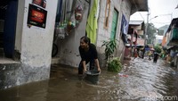 Sejumlah warga membersihkan rumah mereka dari banjir yang merendam kawasan itu.