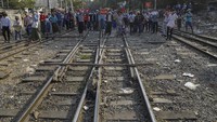 Warga berbaris di sepanjang rel kereta api di Mandalay, Myanmar.