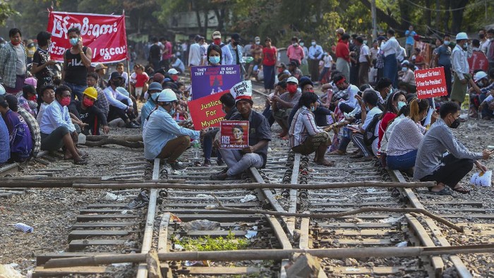 Tolak Kudeta Militer Myanmar, Demonstran Blokir Jalur Kereta Api Demonstrators with placards stand on the railway tracks in an attempt to disrupt train service during a protest against the military coup in Mandalay, Myanmar on Wednesday, Feb. 17, 2021. Demonstrators in Myanmar gathered Wednesday in their largest numbers so far to protest the militaryβs seizure of power, even after a U.N. human rights expert warned that troops being brought to Yangon and elsewhere could signal the prospect of major violence.(AP Photo)
