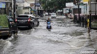 Meski terbilang cukup tinggi genangan airnya, mereka tetap nekat menerobosnya.