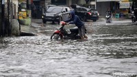 Sebagian dari pengendara terpaksa mendorong motornya yang mogok akibat menerobos banjir.