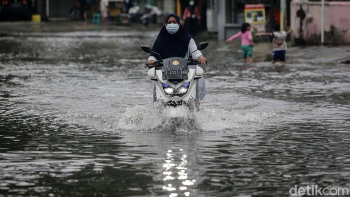 Aksi Nekat Pengendara Terobos Banjir di Taman Duta Depok Banjir merendam Perumahan Taman Duta, Depok, Jawa Barat, Jumat (19/2/2021). Para pengendara pun nekat menerobos banjir di perumahan tersebut.
