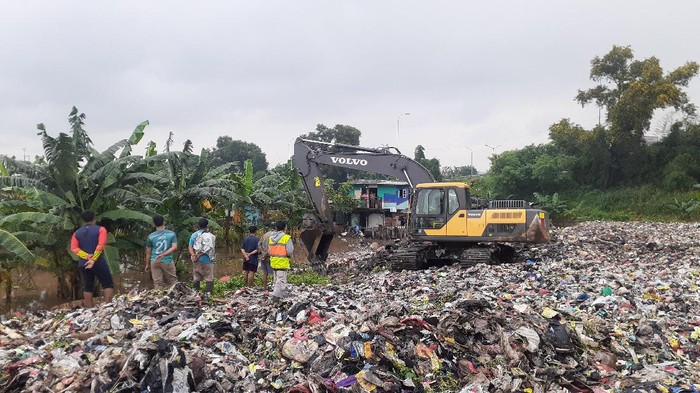 Alat berat siap angkut sampah di tumpukan seluas lapangan bola Kota Bekasi.