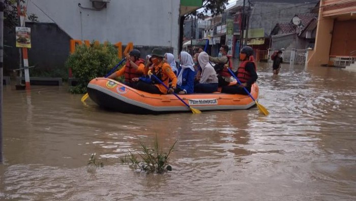 Petugas mengevakuasi korban terdampak banjir di Perum Vila Nusa Indah Gunungputri Bogor, Jumat (19/2/2021).