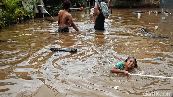 Sejumlah warga beraktivitas di kawasan yang terendam banjir di Cipinang Melayu, Jakarat Timu, Jumat (19/2). Banjir setinggi 1 meter lebih itu sejak jam 3 dini hari tadi. Dan saat ini masih membutuhkan evakuasi dan tempat pengungsian.
