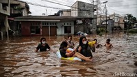 Tanpa rasa takut, sejumlah anak dan remaja ini justru asyik bermain banjir setinggi perut.