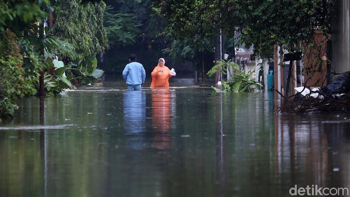 Banjir Jatibening Permai Bekasi Warga melintasi banjir di Perumahan Jatibening Permai, Kota Bekasi, Jawa Barat, Jumat (19/2/2021). Banjir diperumahan ini mencapai 1 meter.
