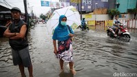 Sejumlah warga bersiaga sambil menunggu banjir surut.