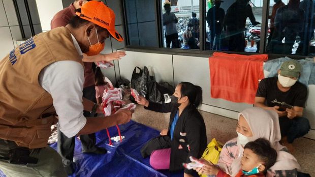 BPBD DKI membagi-bagikan masker ke pengungsi banjir Cipinang Melayu, Jakarta Timur, Jumat (19/2/2021).