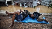 Warga mengungsi ke dataran yang lebih tinggi, tepatnya di samping permukiman yang terendam banjir.