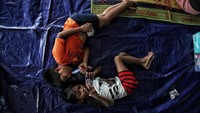Dua orang anak bersantai di pengungsian di sudut ruangan Universitas Borobudur, Kalimalang, Jakarta timur.  