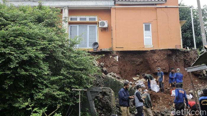 Longsor Ancam Rumah di Depok Petugas tengah melakukan pembersihan sisa-sisa longsor di kawasan Griya Merdeka Timur, Depok, Jawa Barat, Jumat (19/2/2021).