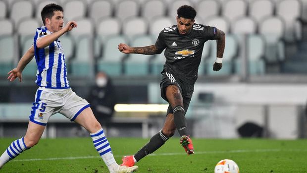Marcus Rashford TURIN, ITALY - FEBRUARY 18: Marcus Rashford of Manchester United scores their sides third goal under pressure from Igor Zubeldia of Real Sociedad during the UEFA Europa League Round of 32 match between Real Sociedad and Manchester United at Allianz Stadium on February 18, 2021 in Turin, Italy. Real Sociedad face Manchester United at a neutral venue in Turin behind closed doors after Spain imposed a ban on travellers arriving from the UK in an effort to prevent the spread of Covid-19 variants. (Photo by Valerio Pennicino/Getty Images)