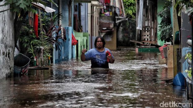 Sejumlah warga menerobos banjir di kawasan Kampung RW04 Cipinang Melayu, Jakarta Timur, Jumat (19/2). Saat ini banjir setinggi 1 meter lebih masih menggenangi kawasan banjir tersebut dan diprediksi jika hujan lagi maka akan lama surutnya