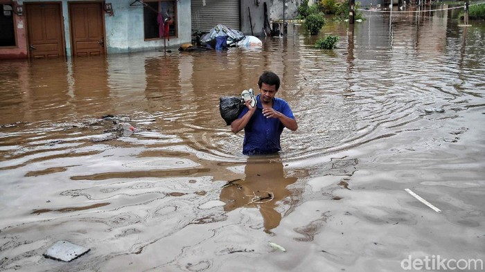 Sejumlah warga menerobos banjir di kawasan Kampung RW04 Cipinang Melayu, Jakarta Timur, Jumat (19/2). Saat ini banjir setinggi 1 meter lebih masih menggenangi kawasan banjir tersebut dan diprediksi jika hujan lagi maka akan lama surutnya