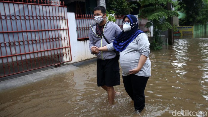 Seorang wanita hamil dievakuasi dari banjir di kawasan Perumahan Masnaga, Bintara, Kota Bekasi, Jawa Barat, Jumat (19/2/2021).