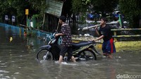 Kendaraan tidak bisa melintas di jalan utama perumahan karena terendam banjir.
