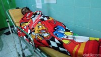Seorang pengungsi terbaring lemas di ranjang Puskesmas usai mengalami keracunan.