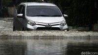 Sebuah mobil nekat menerobos banjir di Perumahan  Bumi Satria Kencana.