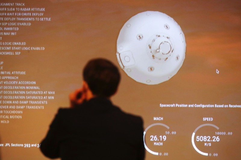 French President Emmanuel Macron attends a viewing meeting of the landing of the NASA Perseverance Mars rover on the planet Mars at the French National Center for Space Studies (CNES) in Paris, Thursday, Feb. 18 2021. A NASA rover streaked through the orange Martian sky and landed on the planet Thursday, accomplishing the riskiest step yet in an epic quest to bring back rocks that could answer whether life ever existed on Mars. The Perseverance rover carries the SuperCam instrument, built by a US-French team of several dozen engineers and scientists from CNES, CNRS and universities. (Christophe Petit Tesson, Pool via AP)